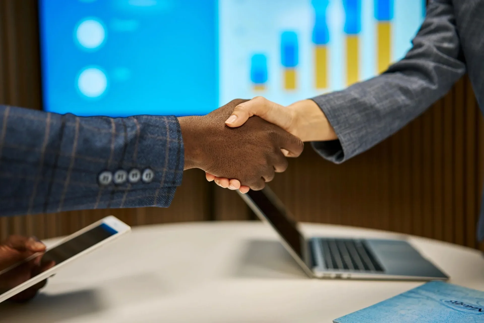 Business handshake over laptops